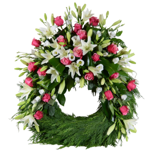 Blomsterkrans med rosa rosor och vita liljor arrangerade på gröna blad.